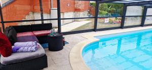 a couch sitting next to a swimming pool at Villa Zelly in Sancergues