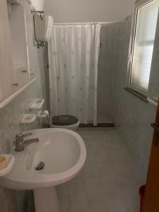 un bagno con lavandino, WC e doccia di Residenza le Saline a Santa Maria
