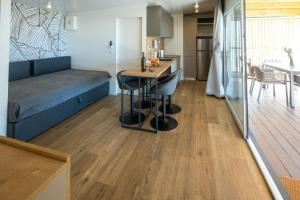 Una habitación con una cama y una cocina con una mesa. en Mobilna kućica Lux, en Turanj