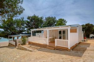 una casa en la playa con porche en Mobilna kućica Lux, en Turanj