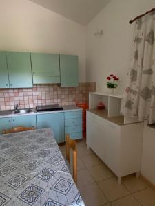 una cucina con mobili blu e un tavolo con un tavolo gmaxwell gmaxwell gmaxwell di Residenza le Saline a Santa Maria Altre 23 foto