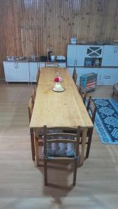 a wooden table with chairs and a vase on it at Guest House Gabo in Mestia +28 photos
