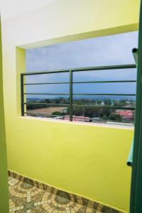 a yellow room with a window with a view at Marie's Studios Naivasha in Naivasha