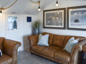 a living room with a brown couch and pictures on the wall at Ludlow Bank in Caulderton