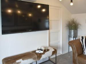 a living room with a large flat screen tv on a wall at Ludlow Bank in Caulderton