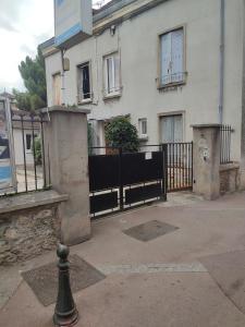 a white building with a black fence and a house at Le Studio de Savigny in Savigny-sur-Orge