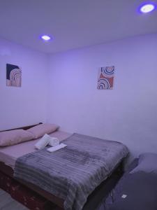 a bedroom with a bed in a white room at Pearl staycation in Buaya