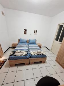 a bedroom with two beds on a tiled floor at Lovely Paceville Studio D in St. Julianʼs