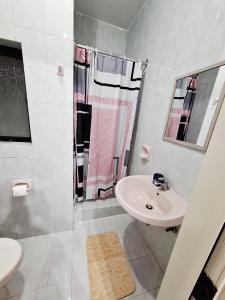 a white bathroom with a sink and a shower at Lovely Paceville Studio D in St. Julianʼs +9 photos