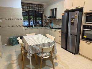 シャー・アラムにあるThe Haven at Divina with Kids Pool!のテーブルと椅子、冷蔵庫のあるキッチン
