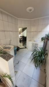 アラルアマにあるCasa dentro de condomínio em Araruamaのトイレと植物が置かれたタイル張りのバスルーム +13枚の写真