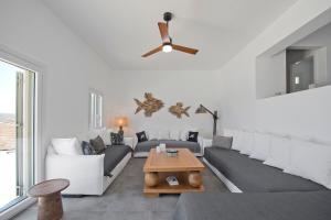 un soggiorno con un divano e un ventilatore a soffitto di Memos Luxury Living at Kithnos a Kithnos