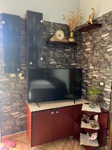 een grote flatscreen-tv op een bakstenen muur bij Elmir apartament's in Ksamil