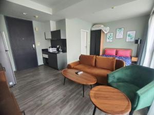 a living room with a couch and a table at The Deck Condo Patong with mountain view in Patong Beach
