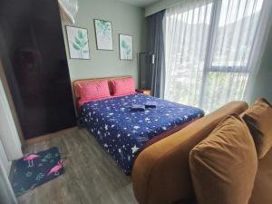 a bedroom with a bed and a couch and a window at The Deck Condo Patong with mountain view in Patong Beach +7 photos