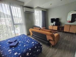 a hotel room with a bed and a couch at The Deck Condo Patong with mountain view in Patong Beach