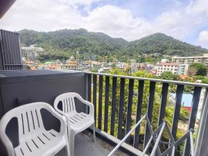 two chairs on a balcony with a view of the city at The Deck Condo Patong with mountain view in Patong Beach