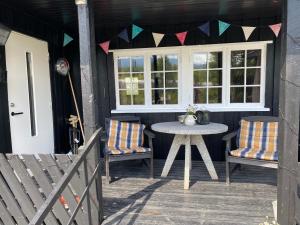 eine Terrasse mit 2 Stühlen, einem Tisch und einem Fenster in der Unterkunft Golsfjellet in Gol