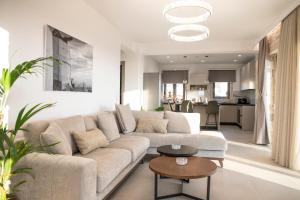 a living room with a couch and a table at Villa Sofita Komos View in Pitsidia