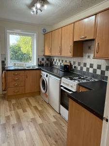 a kitchen with a stove and a dishwasher at 3 bedroom home Kirkcaldy in Fife