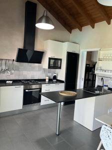 Una cocina con gabinetes blancos y una encimera negra. en LA ERA 1, en Cotillo