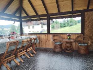 a dining room with a table and wicker chairs at Casa de pe Uliță in Fundata +27 photos