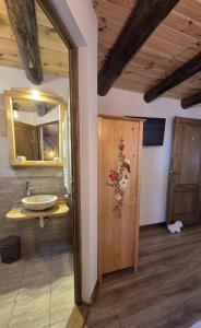 a bathroom with a sink and a mirror at Casa de pe Uliță in Fundata