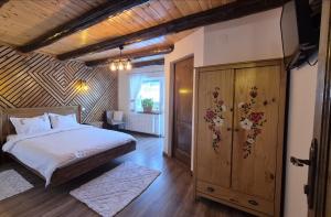 a bedroom with a bed and a wooden wall at Casa de pe Uliță in Fundata