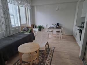 a small living room with a bed and a table at New Center City Home in Kuopio