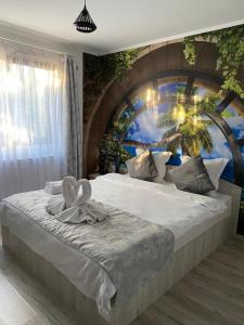 a bedroom with a large bed with a mural on the wall at Casa Ratiu Apartamente 3 stele Airport Bucharest Therme Bucharest in Baloteşti