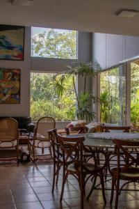 a dining room with a table and chairs and windows at Sossego Homestay - Chapada dos Guimarães in Chapada dos Guimarães