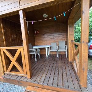 a wooden deck with a table and chairs in a cabin at Domki letniskowe SOKÓŁ in Okuninka