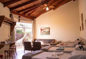 a room with four beds and a table and chairs at Sossego Homestay - Chapada dos Guimarães in Chapada dos Guimarães