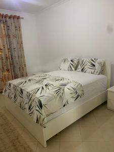 a bedroom with a bed with white sheets and pillows at Entire Apartment near Air Albania in Tirane