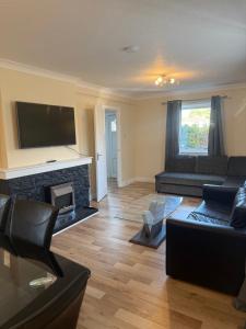 a living room with a couch and a fireplace at 3 bedroom home Kirkcaldy in Fife