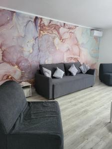 a living room with a couch and a painting on the wall at Casa Ratiu Apartamente 3 stele Airport Bucharest Therme Bucharest in Baloteşti