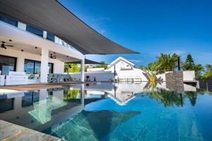 Kolam renang di atau dekat dengan SUMMER VIEW classée 5 étoiles - Magnifique Villa 10 personnes avec piscine miroir chauffée à 29 degrés, bain à remous intégré et vue mer idéalement située Chemin Summer - ST GILLES LES BAINS