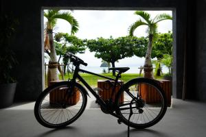 a bike parked in a room with palm trees at Hotel Yagajiso in Nago