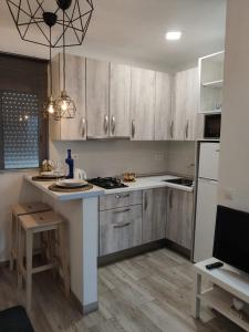 eine Küche mit Holzschränken und einer weißen Arbeitsplatte in der Unterkunft Casa Ventura, en el Corazón dé Tenerife in La Laguna