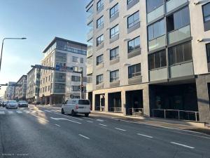 a white van driving down a city street with buildings at New Center City Home in Kuopio