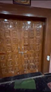 a pair of wooden doors in a room at Rishi home stay in Bhauli