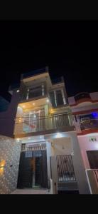 a large white building with a balcony at night at Rishi home stay in Bhauli