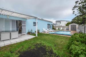 a blue house with a yard with a swimming pool at Family Tides in Yzerfontein