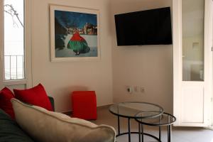 a living room with a couch and a table at Péra Skopelos - Mesa Nifi in Skopelos Town
