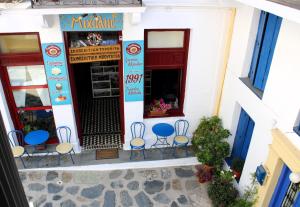a restaurant with blue chairs in front of a building at Péra Skopelos - Mesa Nifi in Skopelos Town