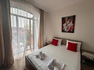 a bedroom with a bed and a large window at Hotel Port Altus in Batumi