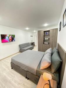 a bedroom with a bed and a couch and a chair at Arena 63 in Bogotá