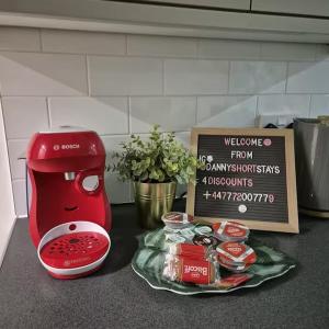 a kitchen counter with a red mixer and a sign at City Penthouse with 3 floors , Super King Bed , with secret garden in Birmingham