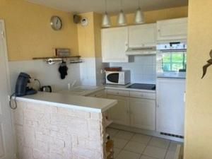 a small kitchen with white cabinets and a microwave at Appartement en bord de mer pour 4 pers avec balcon, parking et animaux admis - FR-1-236-169 in Cucq