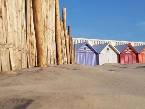 a row of colorful beach huts next to a fence at Appartement en bord de mer pour 4 pers avec balcon, parking et animaux admis - FR-1-236-169 in Cucq